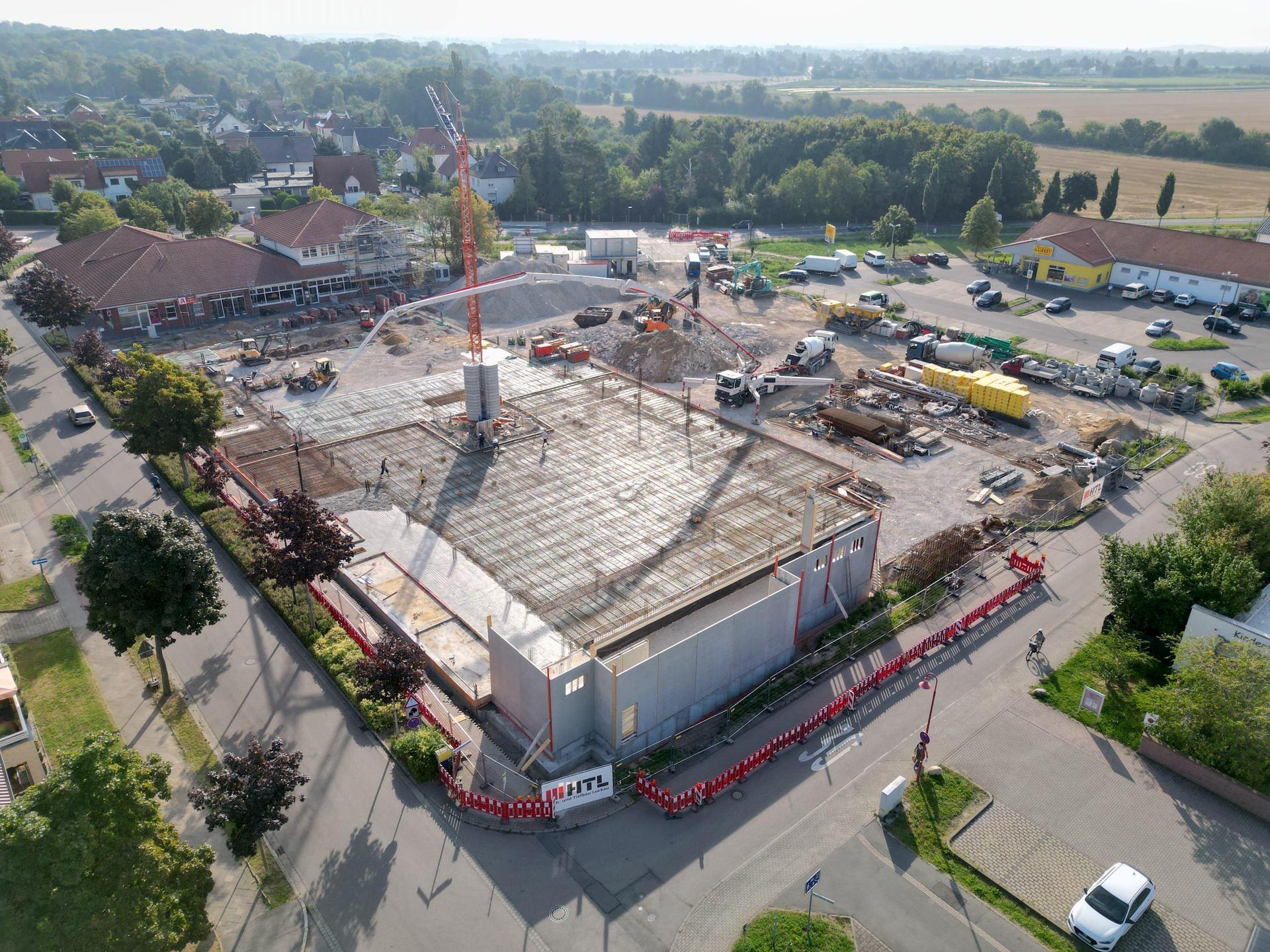 Beton, Stahl und Schwerlasttechnik im Einsatz: Auf der Baustelle des neuen REWE-Markts in Taucha wird die erste Bodenplatte gegossen – ein weiterer Schritt hin zum geplanten Green Building. (Foto: Daniel Große)