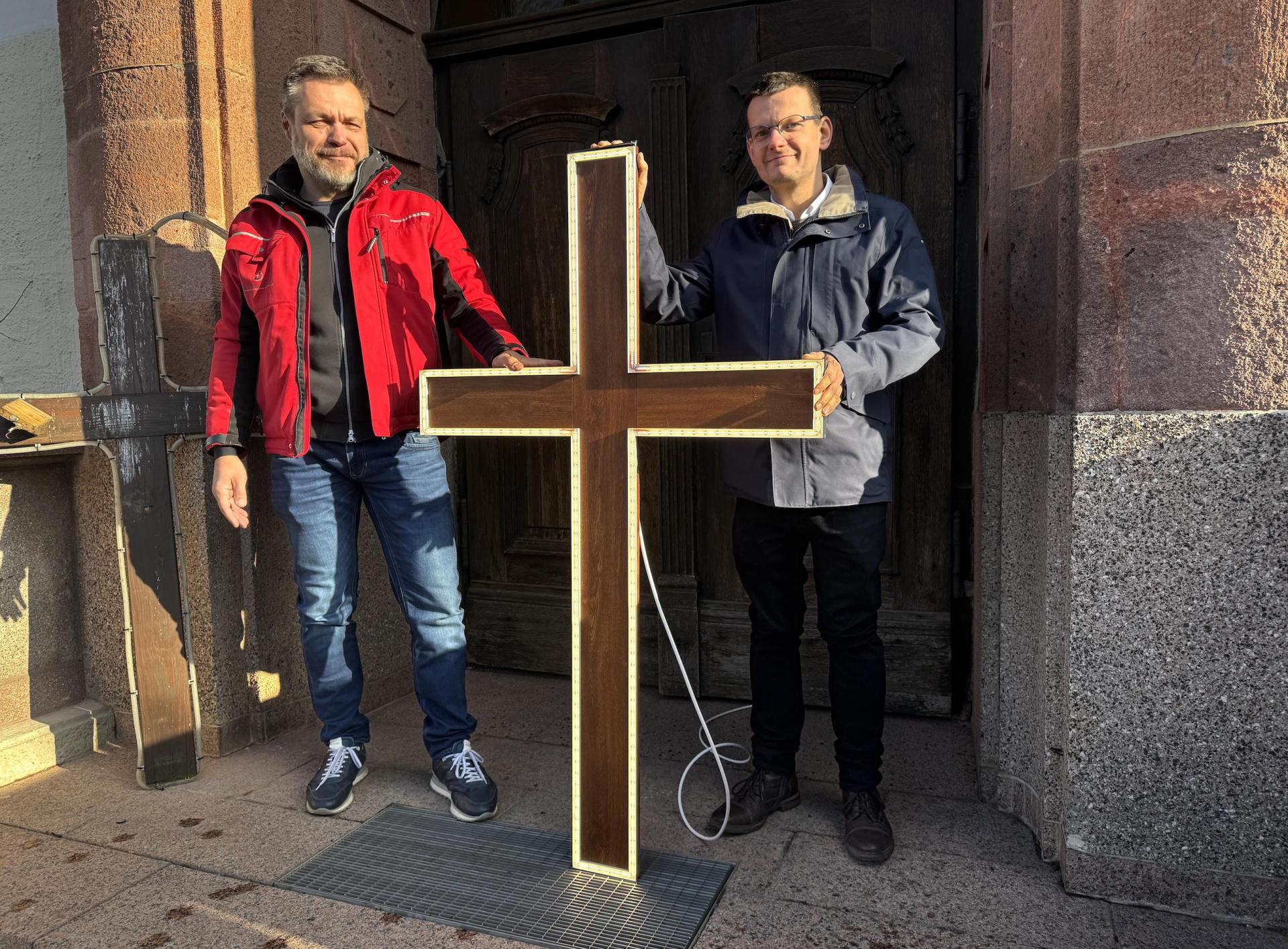 Heiko Zettelmann und Nico Piehler präsentieren die neuen Lichtkreuze für die Kirche St. Moritz. (Foto: Daniel Große)