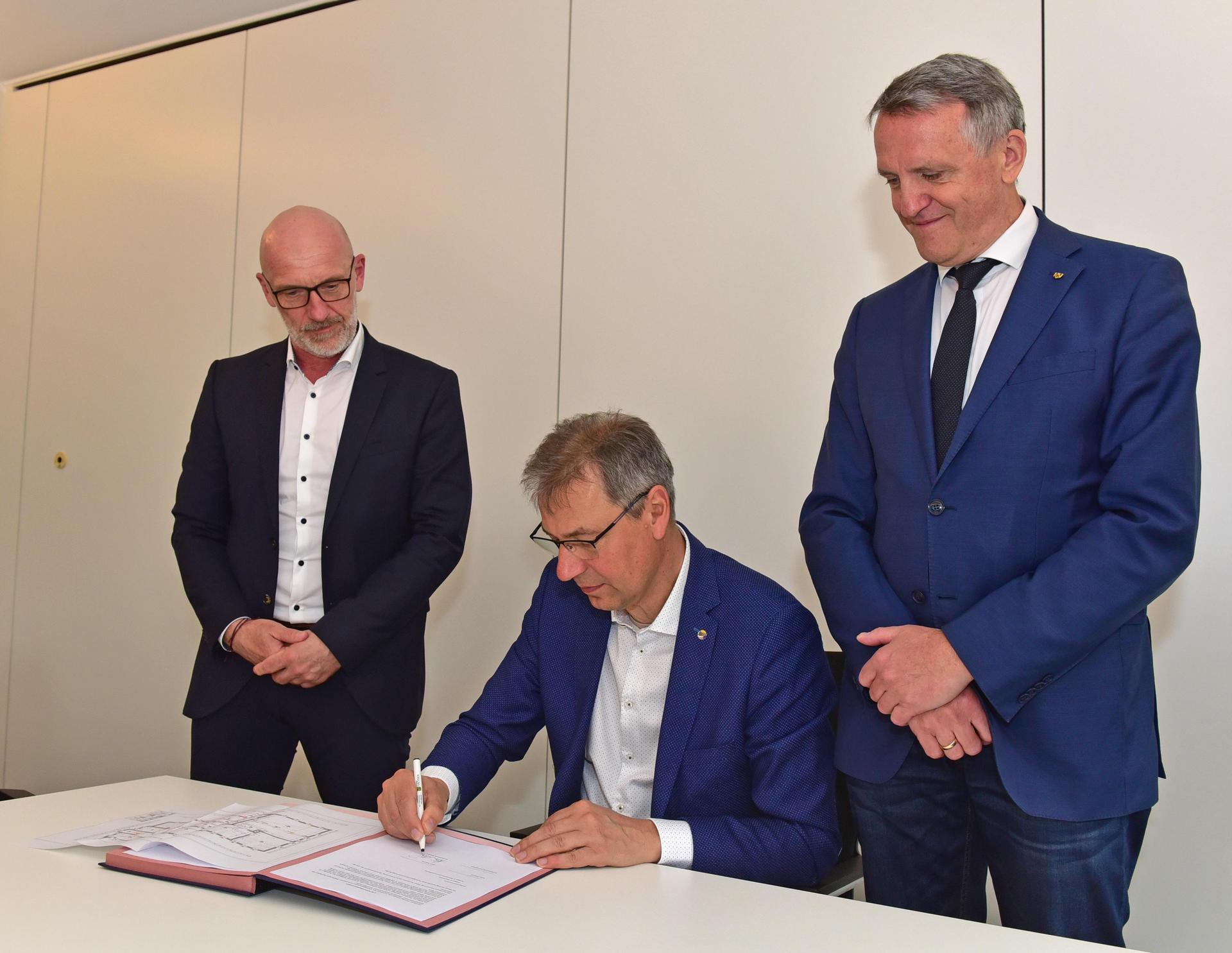 Landrat Kai Emanuel unterzeichnet im Beisein von WGD-Geschäftsführer André Planer (l.) und Oberbürgermeister Manfred Wilde (r.) den Mietvertrag. 				 (Foto: Foto: LRA/Bley)