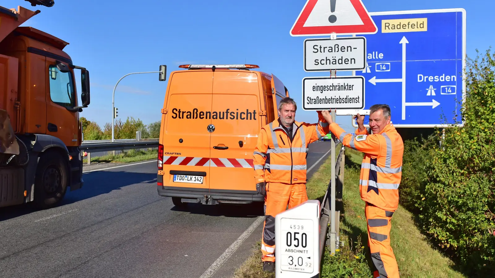 Warnschild-Aktion an der Staatsstraße S 1 bei Radefeld: Nordsachsens Landrat Kai Emanuel (r.) mit Bernd Scheffler von der Straßenmeisterei Delitzsch. (Foto: Alexander Bley / LRA Nordsachsen)