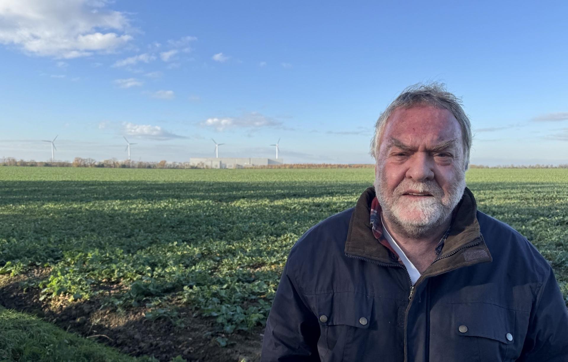 Die Windräder von BMW und das Gewerbegebiet hat Roland Wagner am Rand seines Grundstücks ständig im Blick. Das Feld hinter ihm würde es mit der Erweiterung des Gewerbegebietes nicht mehr geben. (Foto: Daniel Große)